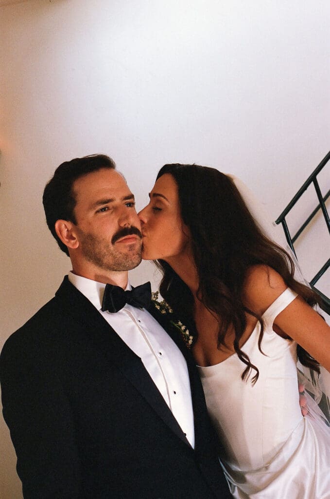 bride kissing the groom on the cheek